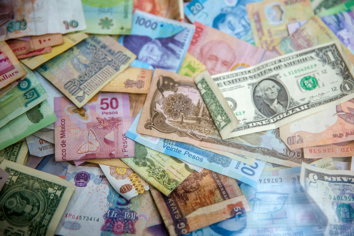 Billetes de distintos países sobre una mesa, referencia de presupuesto y precio